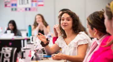 LOLA Leadership Training program card showing women in a professional training session